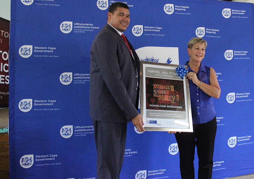 Cederberg Municipality Mayor William Farmer receives a framed poster from Minister Anroux Marais at the launch of the Oral History Initiative