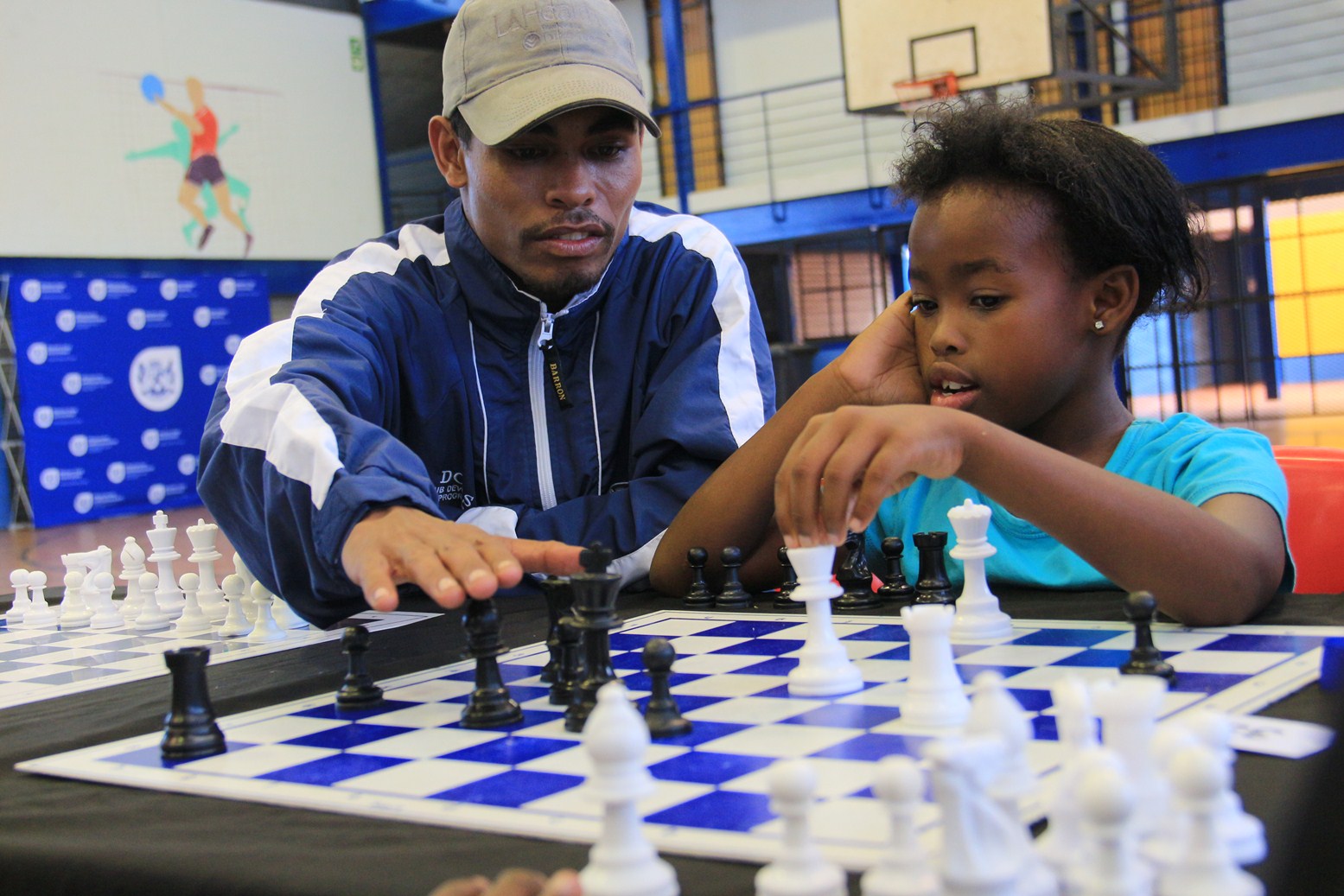 Chess coach Godfrey Mohammed teaches Zimbino Mayo from Gugulethu how to play chess.