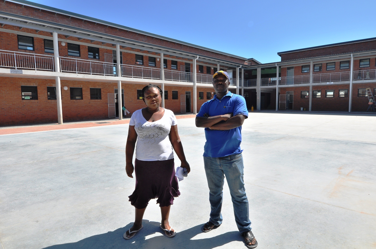Community Liaison Officer Patricia Beza and Project Chairperson Chris Mntuyedwa in front of the double-storey building.