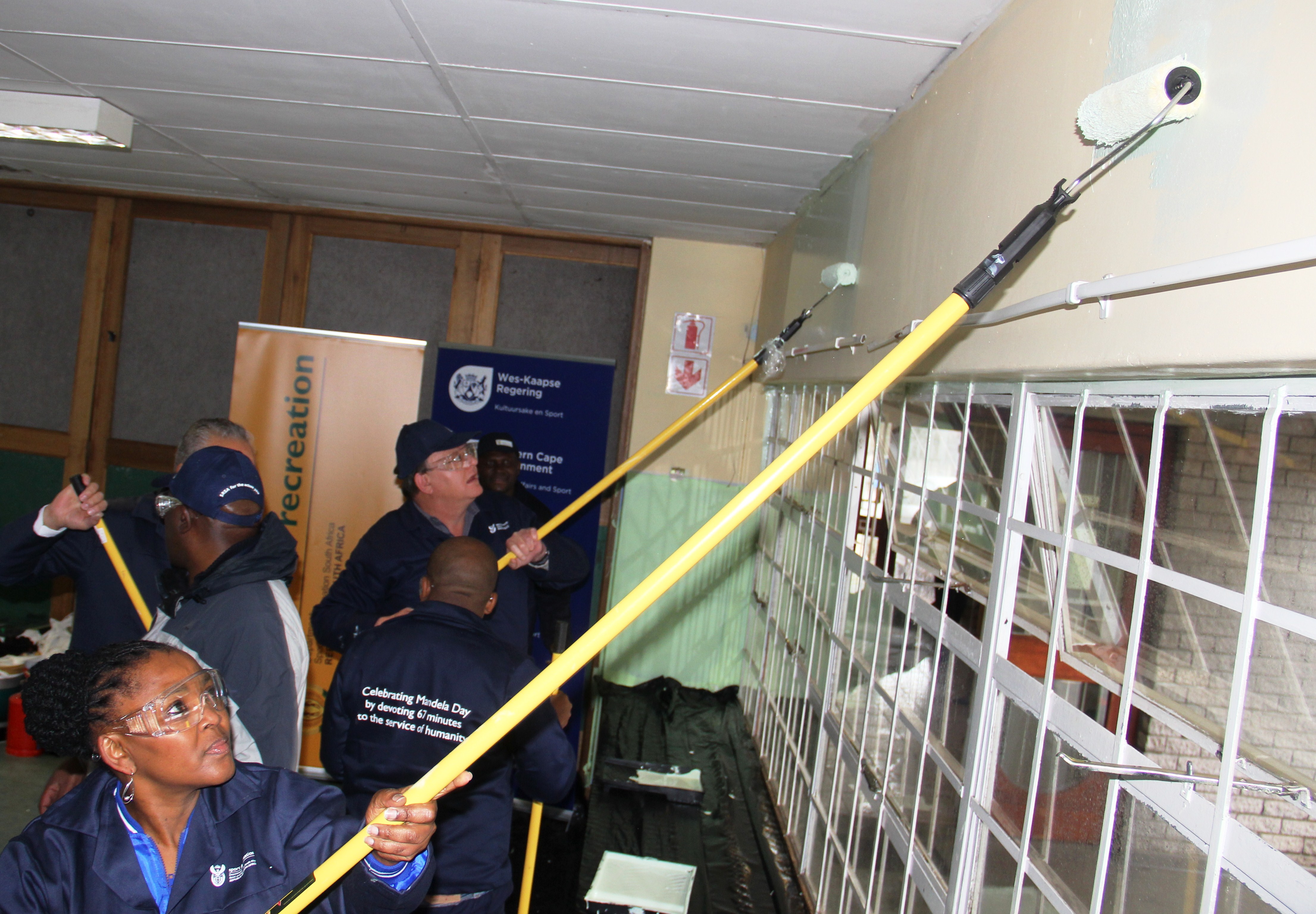 SRSA deputy minister Gert Oosthuizen and Dr Nomafrench Mbombo paint the Salvation Army Crèche in Manenberg.