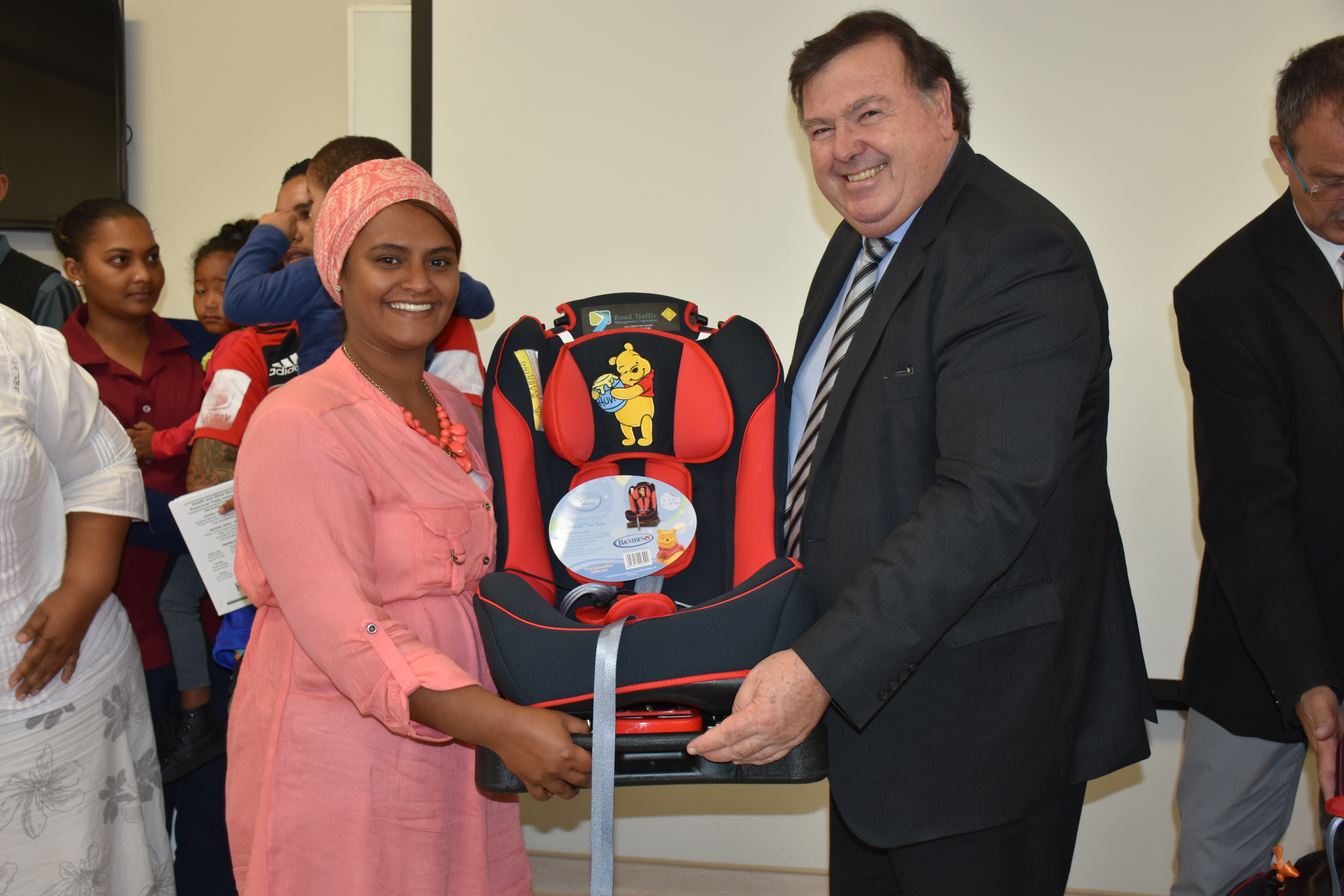 Minister Grant handing over a donated car seat to Ms Fadwa Adams at the event this morning.