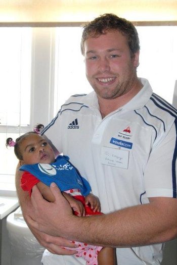 Stormers player JC Kritzinger, holds baby Tamia, who underwent cleft lip and palate surgery at Red Cross War Memorial Children's Hospital. JC took part in the Vodacom Foundation's Tries for Smiles campaign which raised funds for the Smile Foundation
