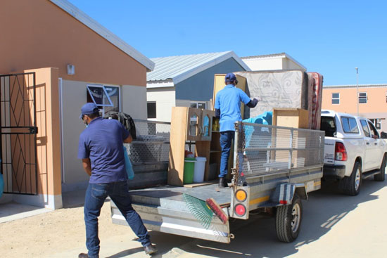 Trailer being unloaded as beneficiaries are moving in