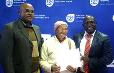 Proud 78 years old Sonia Wiener accepting her title deed from Minister Bonginkosi Madikizela right.