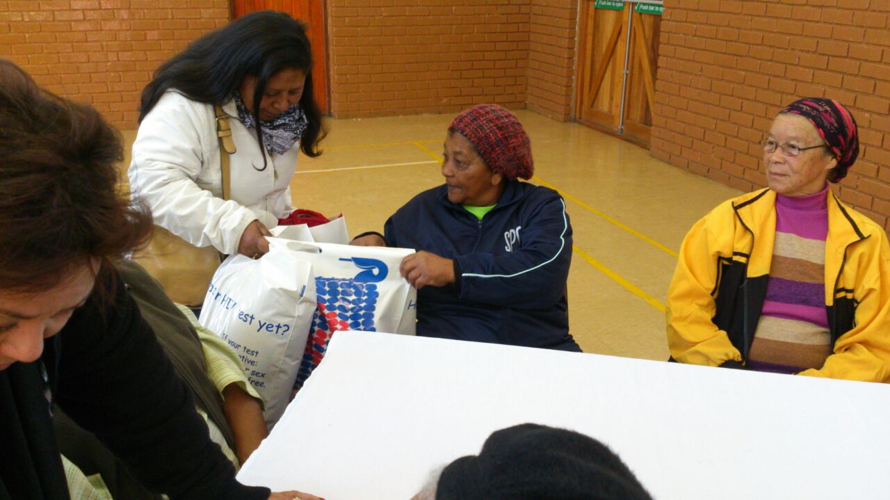Metro South colleague handing over goodies to a member of the Embrace Senior Club 