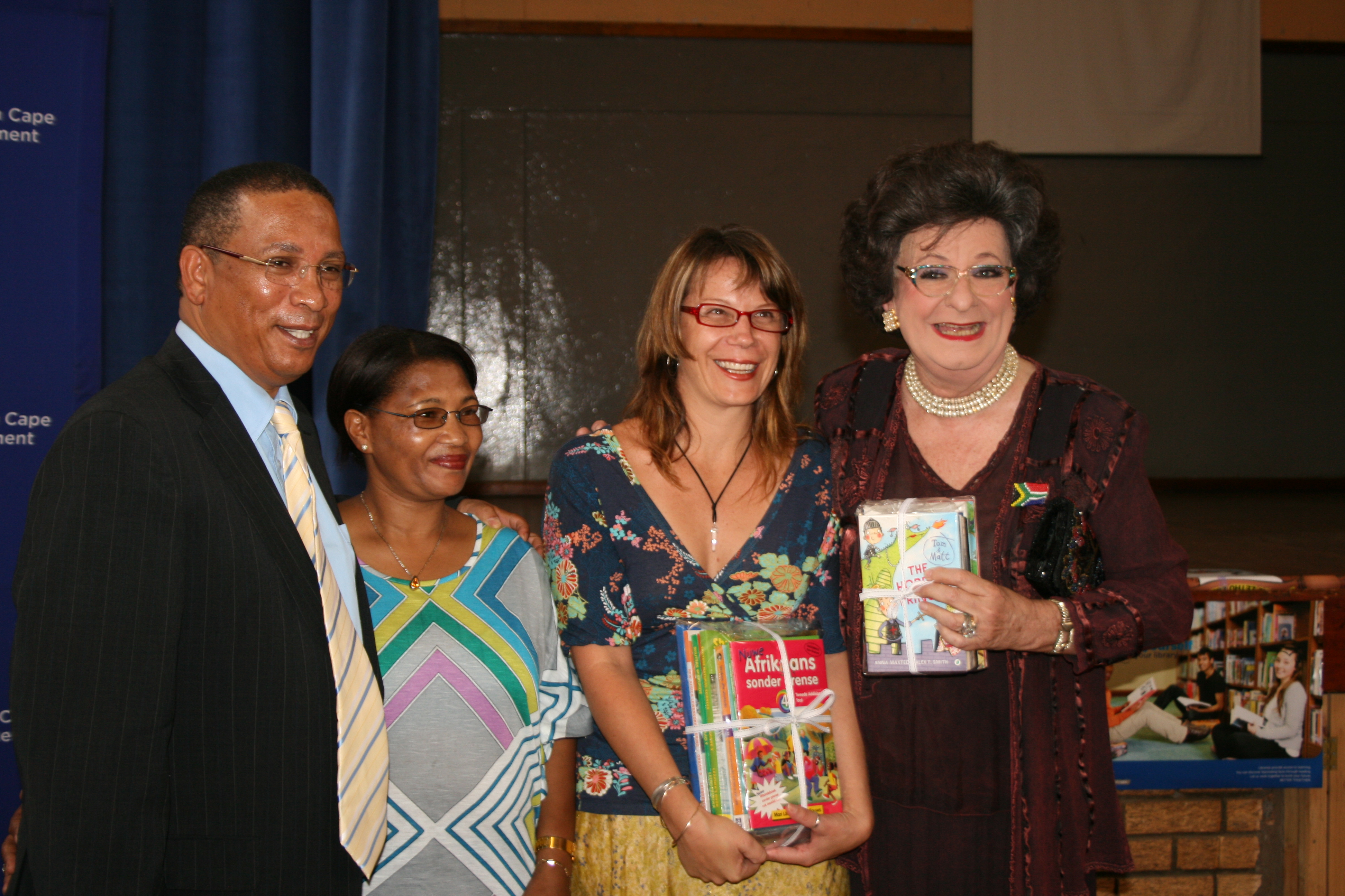 Minister Ivan Meyer handing over books to Evita Bezuidenhout and representatives of the Darling trust.