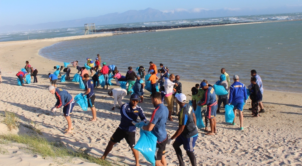 Minister Marais along with WP rugby players and members of the community braved the wind to clean Monwabisi beach.