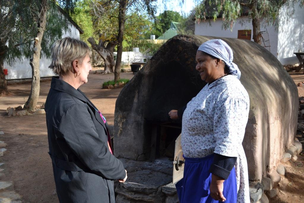 Minister Marais learns how bread is baked in the open air oven at Worcester museum