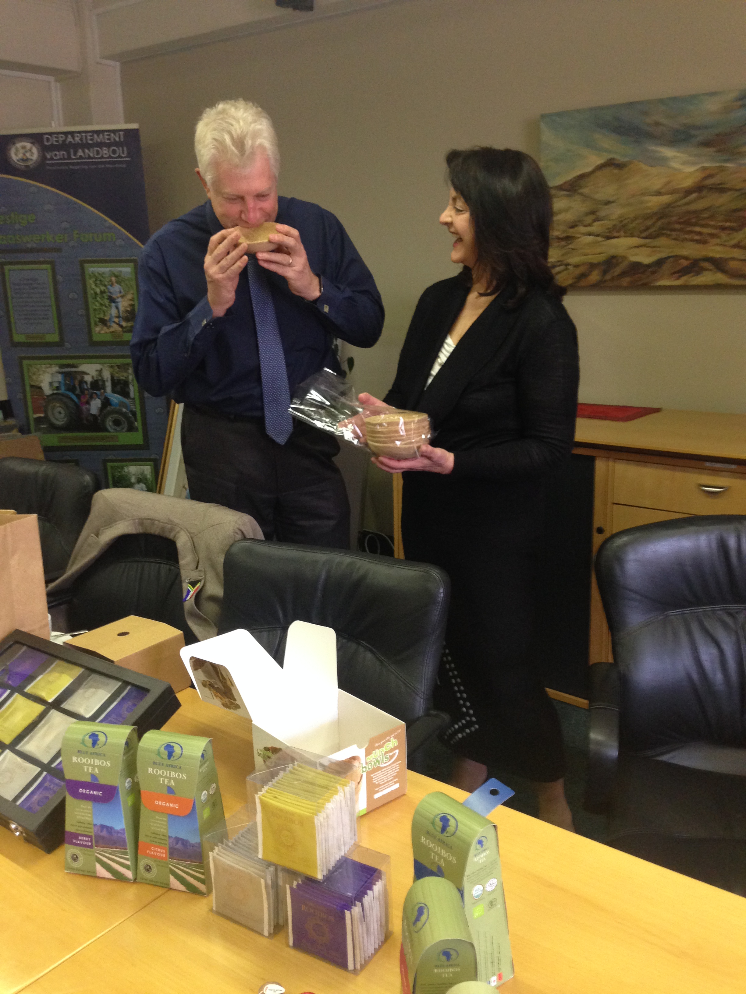 Minister Winde tastes Munch Bowls edible bowls while company founder Georgina de Kock looks on.