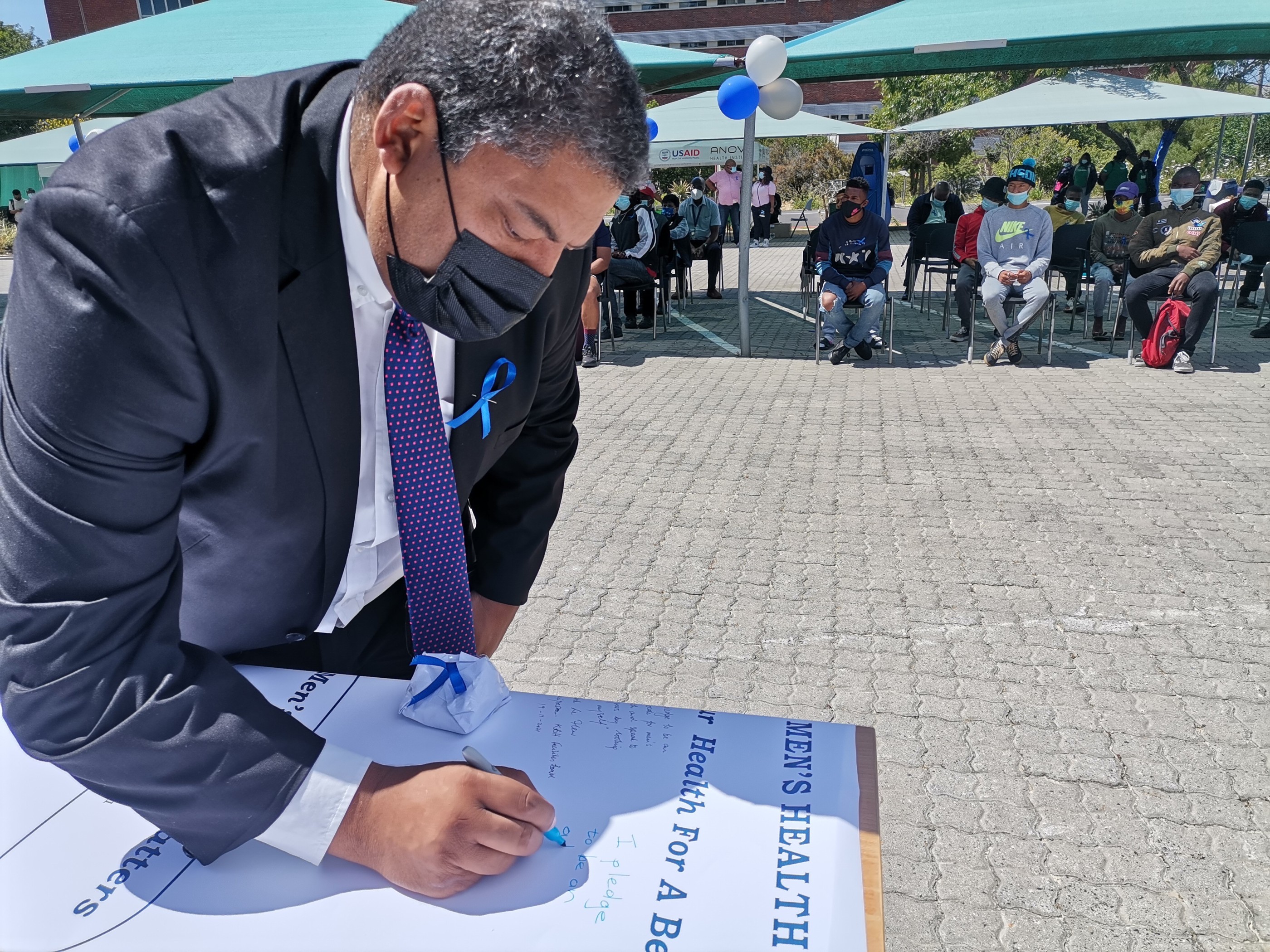 Quinton Adams, educational psychologist, signs the men’s health pledge after addressing young men on their role in society.