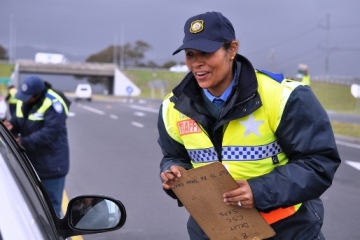 Female traffic official talking to driver during a roadblock