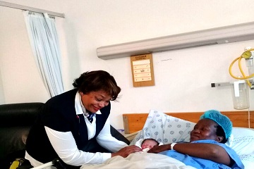 Nurse Gertrude Smit assisting a patient at hospital 