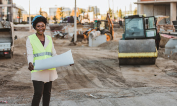 Portrait of professional architect black woman wearing blue helmet and standing outdoors