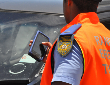 A traffic officer uses a hand-held device.