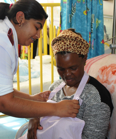 Sister Kajel David (Breastfeeding Champion in Ward B1) showing Ntombekaya Kuse how to use the breastfeeding apron.