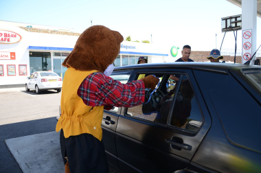 Danny Cat hands out flyers to vehicle occupants.