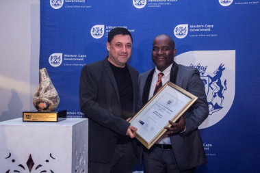 Director Mxolisi Dlamuka presents an award to the Magnet Theatre Education Trust at the 2016/17 Cultural Affairs Awards Ceremony