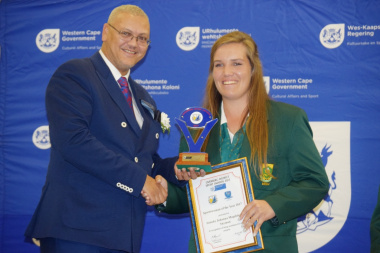 Dr Lyndon Bouah handing over the sportswoman of the year award to Aneke Snyman from Overberg Lawn Bowls.