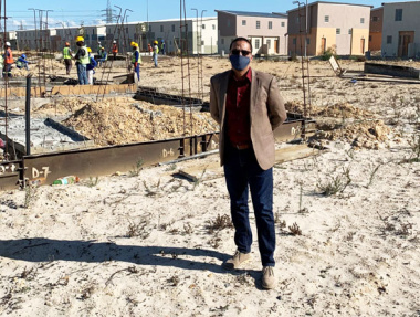 Western Cape Minister of Human Settlements, Tertuis Simmers with workers in the background