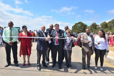 Lincoln de Bryn, Mayor of the Overberg District Municipality, Reverend D Dietrich, Minister Grant, and Nicolette Botha-Guthrie, Mayor of the Overstrand Local Municipality, flanked by municipal officials and guests.