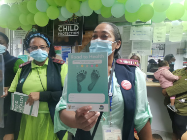 Healthcare workers explain the importance of child immunisations and good nutrition using the Road to Health book that new parents receive when their child is born.