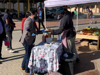 Minister Simmers engaging residents in Pacaltsdorp and purchasing a boerewors roll from a vendor in Thembalethu