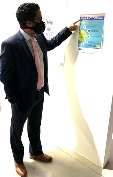 Western Cape Minister of Human Settlements, Tertuis Simmers is pointing to a flyer which explains how to log a complaint online