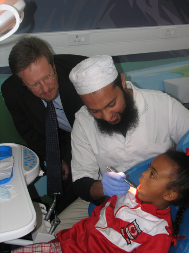 Minister Theuns Botha and Dr Faheem Ganie who is  examining a young learner's teeth from St Thomas Primary.