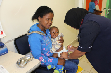 Nine month old Prince Chuman Simamkel and Mom, Sithabile Dube watch carefully while the nurse immunises him. 