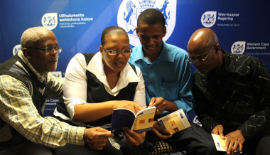 Lungile Fihla (Human Settlements), Nonzwakazi George (Provincial Treasury), Xolisa Tshongolo (DCAS) and Vuyani Nkunzi (City of Cape Town) admire the isiXhosa terminology booklet