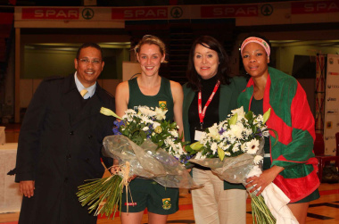 Dr Ivan Meyer with a representative from Netball South Africa and national players Erin Burger and Zanele Ndodana on the occasion of their 50th test caps.