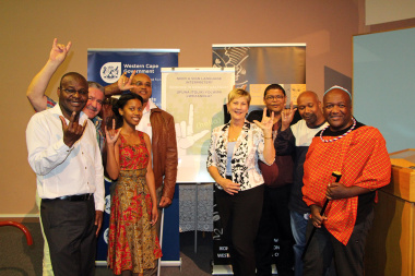 Minister Anroux Marais and other VIPS with the new poster, practising their Sign Language