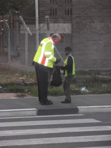 Minister Carlisle assisting an Imbasa Primary School Learner to cross the busy street