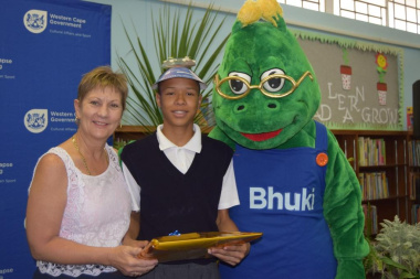 Minister Anroux Marais and mascot Bhuki awarded Joshwin Bizaare for improved reading skills at the afternoon classes at the Monte Rose Library