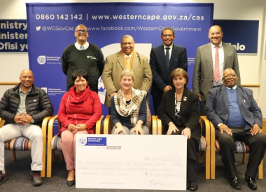 Minister Anroux Marais and Dr Lyndon Bouah with municipal representatives at the cheque handover ceremony in Cape Town