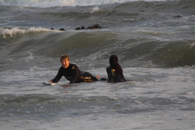 Minister Marais surfing the waves under the guidance of 9Miles project facilitator Nathaniel Stemmet.
