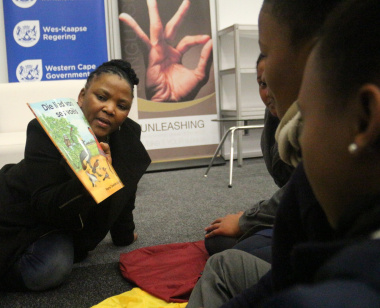 Minister Mbombo engages with learners during an interactive story-telling session.