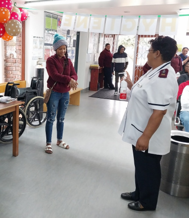 Local resident Rowena Kees demonstrates the correct way of washing your hands, as shown by Operational Manager Sr Elize Esau from Melkhoutfontein Clinic near Stilbaai.