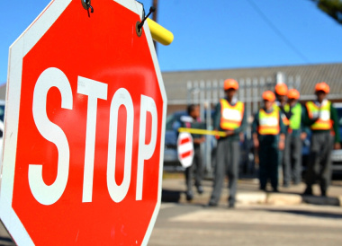 Scholar patrol members regulate traffic slow down vehicles and facilitate safe crossing.