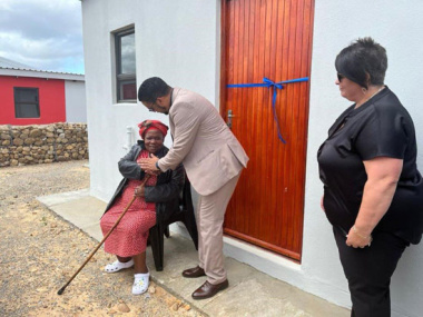 Mrs. Dinah Sibala (75), the first beneficiary receive keys to her brand-new homes from Provincial Minister of Infrastructure Tertuis Simmers and Executive Mayor of Breede Valley Ald. Antoinette Steyn