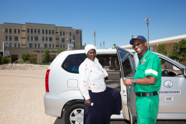 EMS driver Nohani Themelani assists Noluvuyo Mazwayi of Philippi into the new patient transport vehicle.