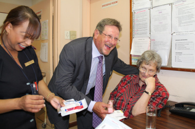 The Western Cape Health Minister, Theuns Botha, shares a light moment during his visit to Zandvlei Care Facility, Macassar, with Sister Mabel van Zyl, Zandvlei Care Facility Manager, and patient Susan Jordaan (64). 