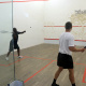 Eager players alternate in striking the ball at the squash court