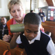 Minister Marais helps one of the learners with the telephone toy