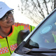 Road safety officer Lizel Plaatjies puts a sticker on a vehicle.
