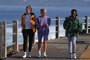 three women brisk walking on the promenade